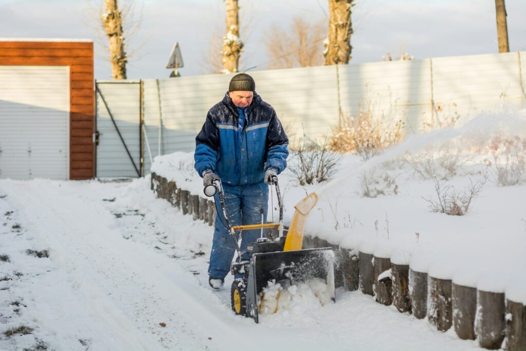 Mann mit Schneepflug Winterdienst Hausverwaltung